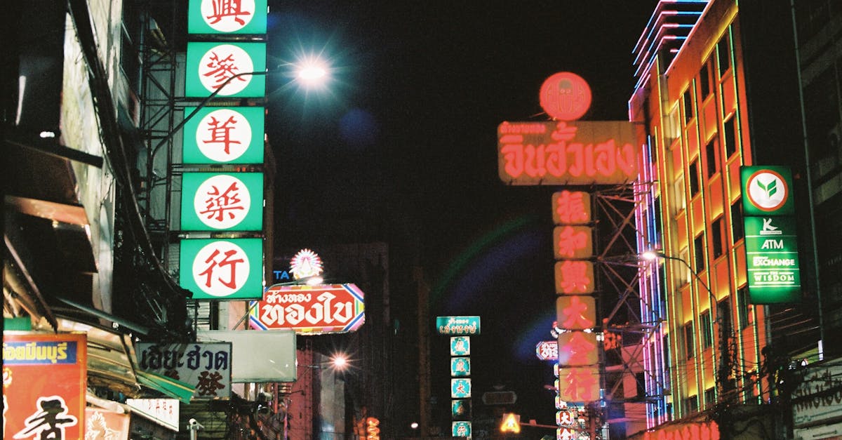 Explore the bustling city street at night, illuminated by colorful neon signs in an urban setting.