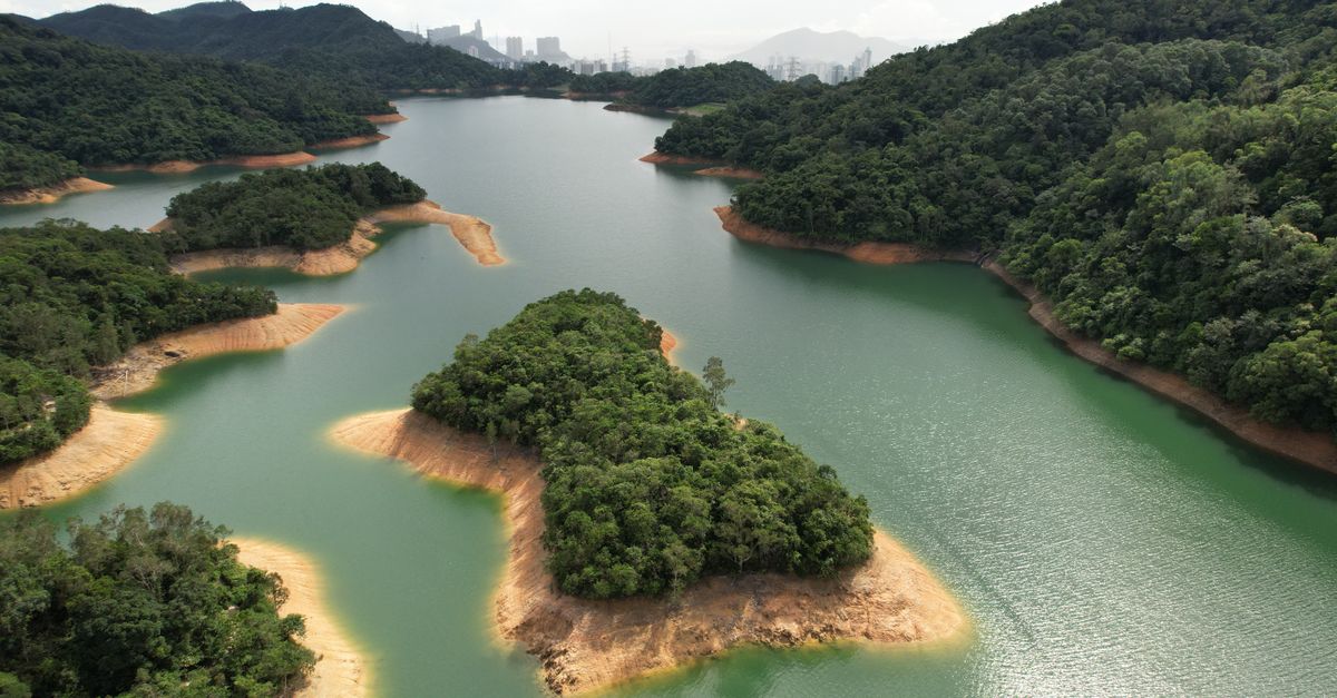 Stunning aerial view of a tranquil lake surrounded by lush green hills in New Territories, Hong Kong.