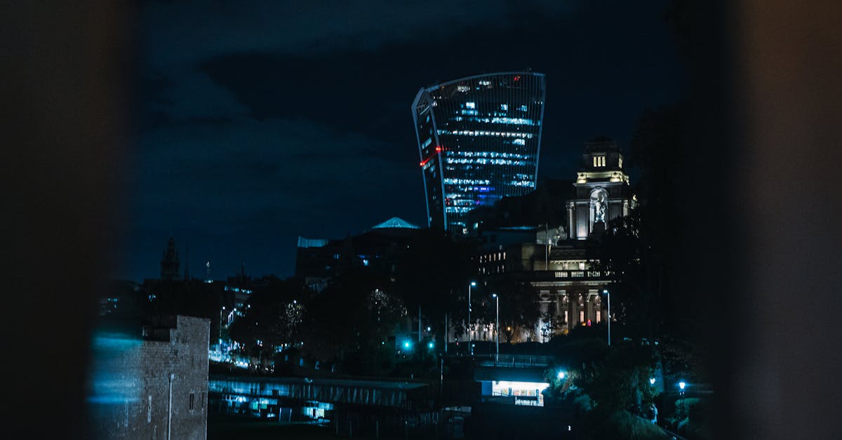Illuminated London skyline at night with iconic skyscraper and city lights.