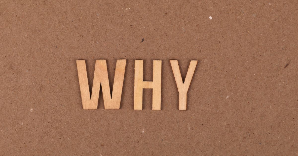 Wooden letters spelling 'WHY' on a brown cardboard background. Ideal for concepts of questioning and curiosity.