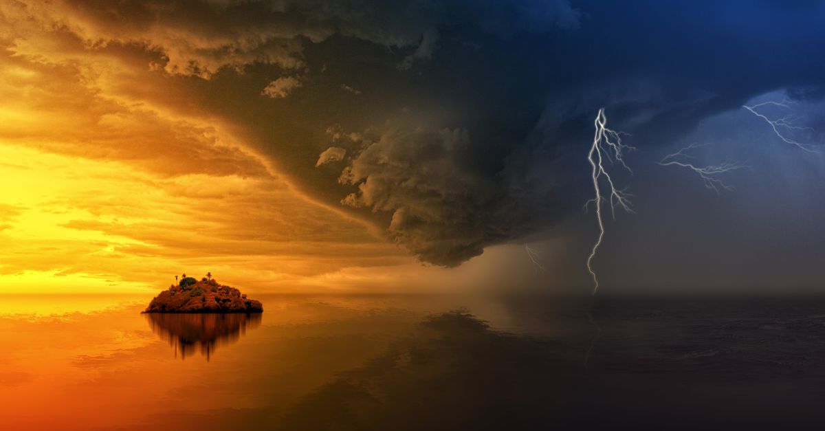 A stunning display of a stormy sunset with lightning striking over a solitary island.