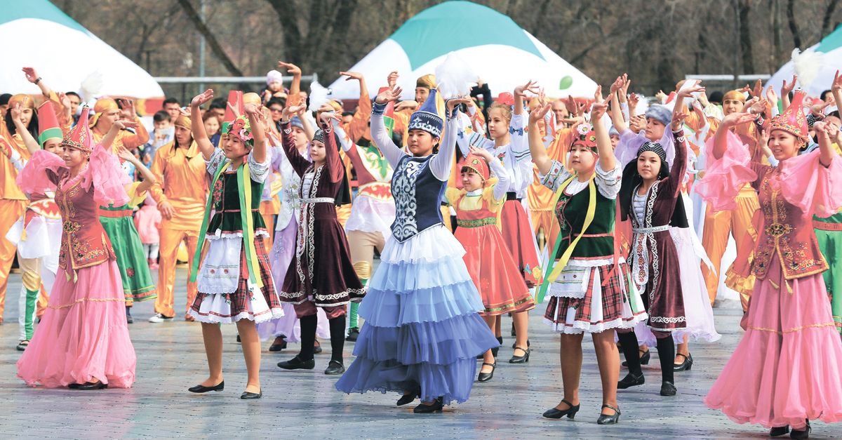 Vibrant group celebration with dancers in traditional costumes performing outdoors.