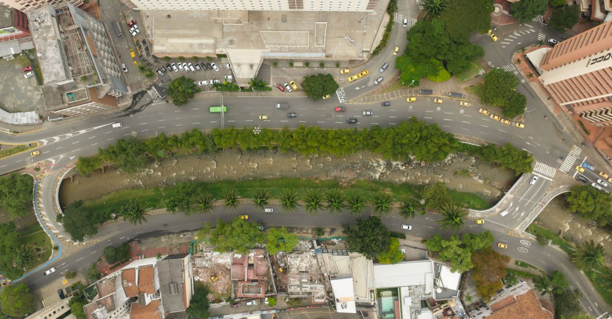 Aerial view showcasing a city's urban layout with roads, greenery, and palm trees.