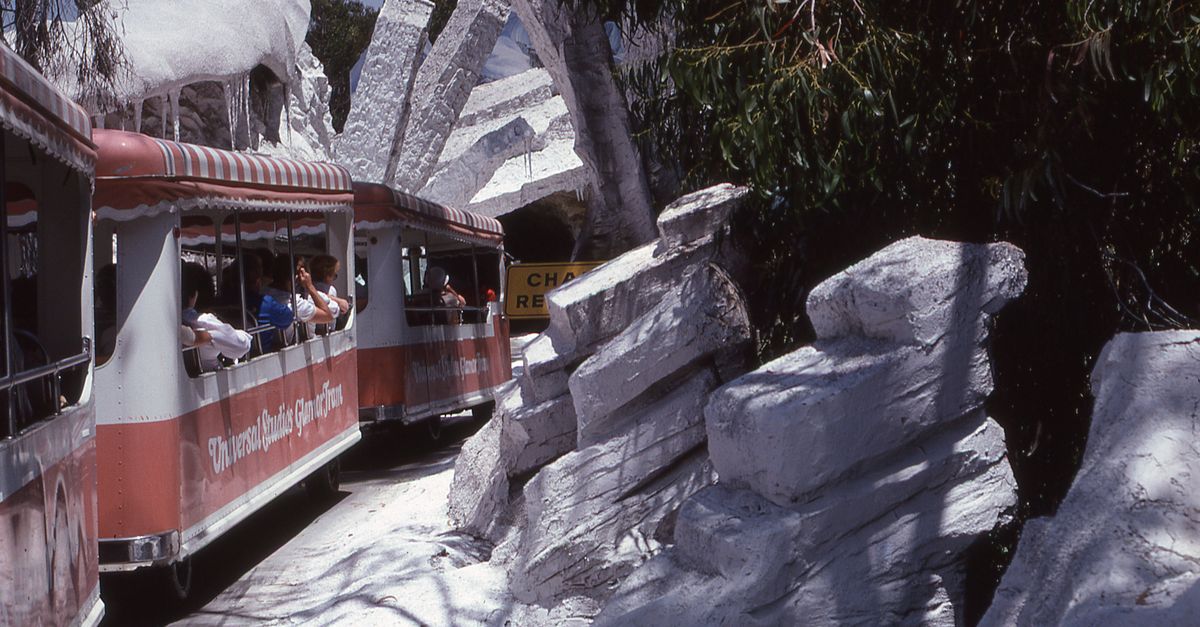 Enjoy a scenic tram ride through a theme park with rocky landscapes and natural beauty.