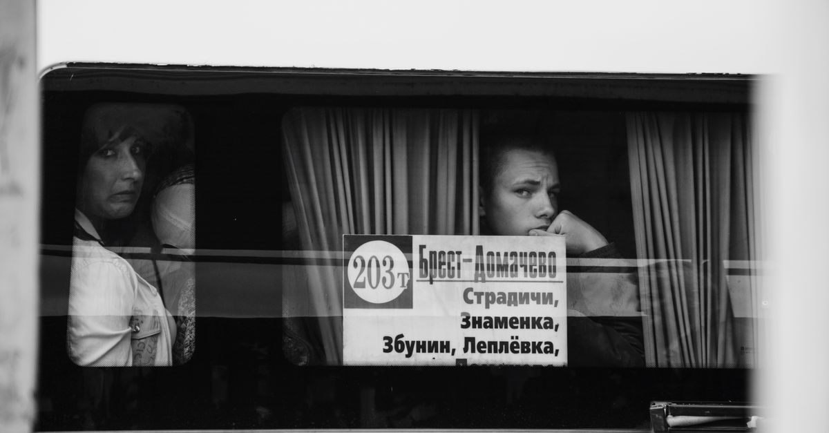 A black and white photo capturing thoughtful passengers gazing out a bus window.