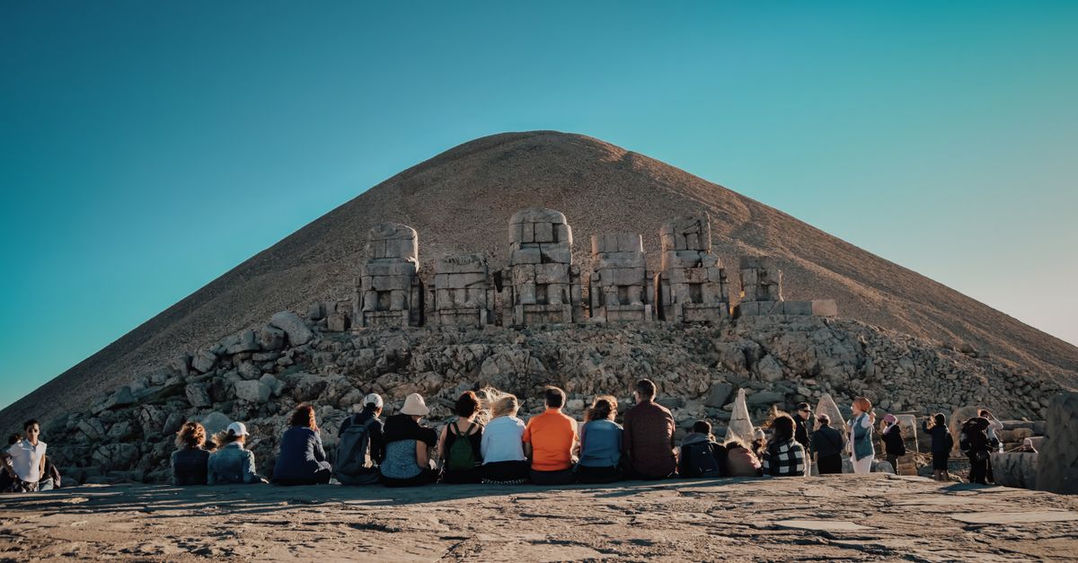 Visitors explore the ancient stone statues at Mount Nemrut, a UNESCO World Heritage Site in Turkey.