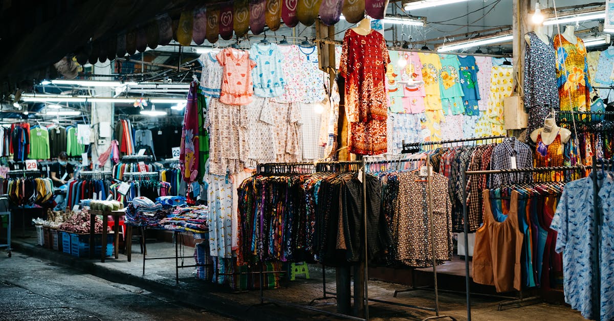 Explore a bustling nighttime street market showcasing vibrant apparel and textiles under bright lights.