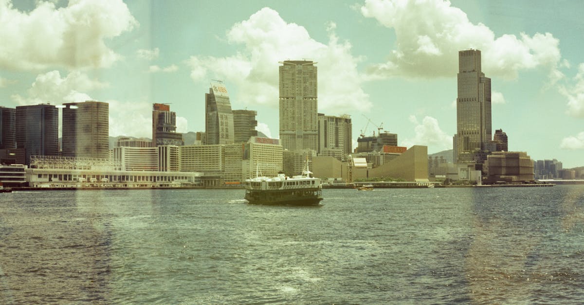 Scenic day view of Hong Kong harbour featuring skyline and ferry.