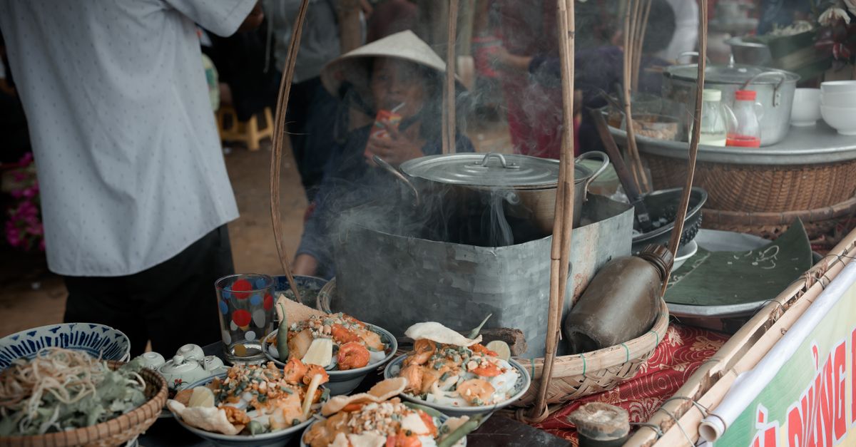 Explore the vibrant atmosphere of a traditional Vietnamese street food market with steaming dishes.