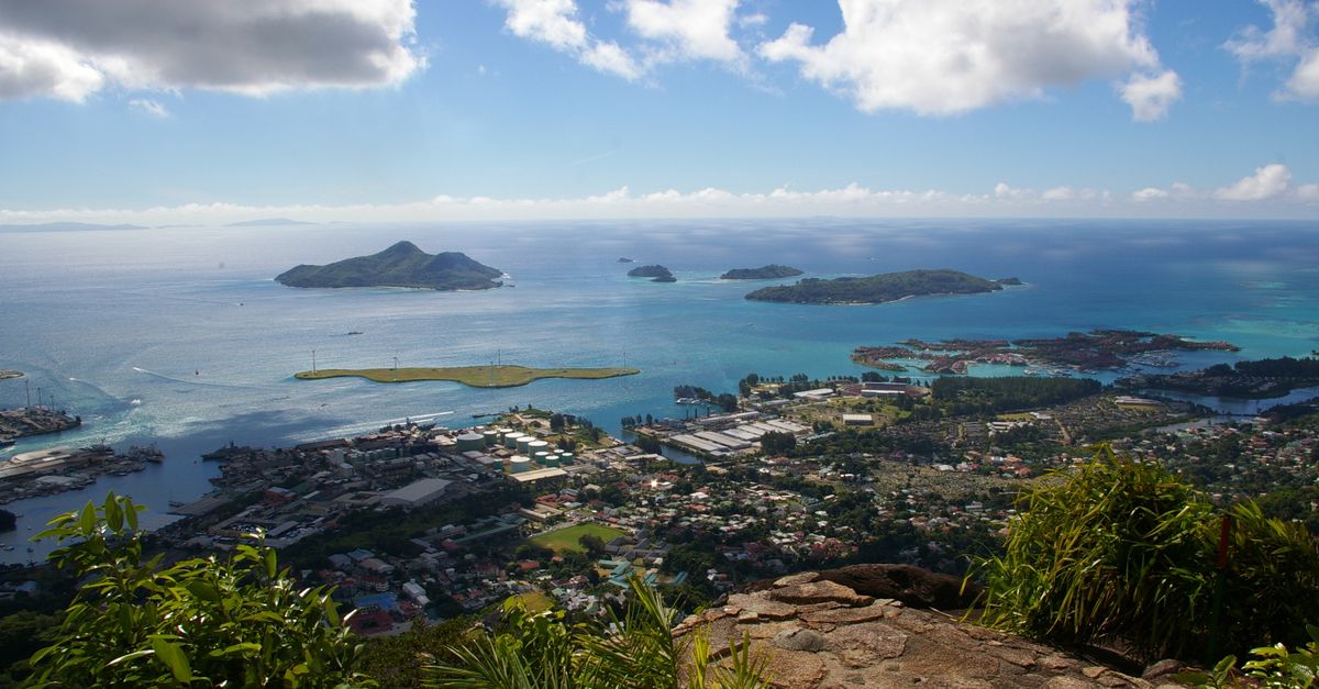 Stunning aerial landscape of Seychelles islands and ocean from a mountain viewpoint under a bright sky.