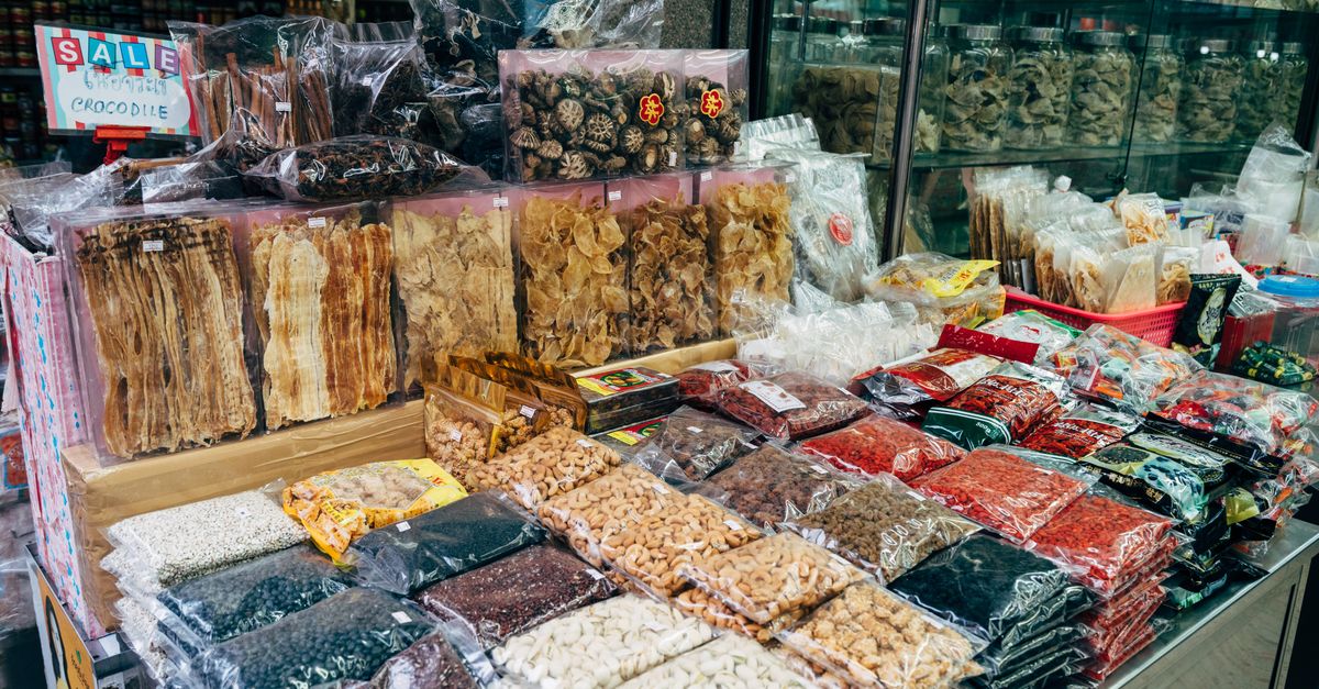 An indoor market stall showcasing a diverse selection of dried foods and spices.