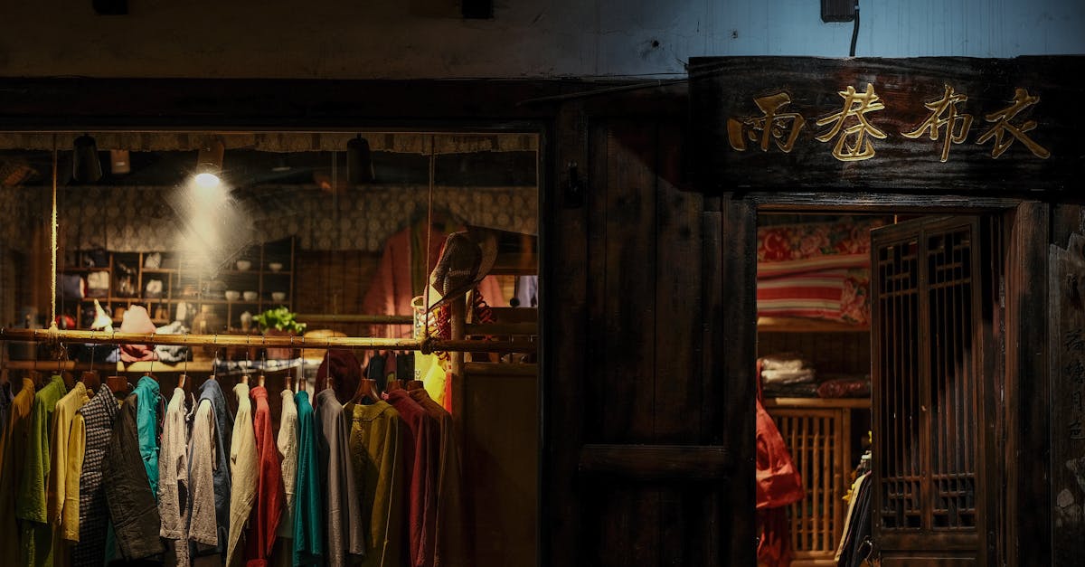 Traditional clothing store facade with colorful garments and Chinese characters in dim lighting.