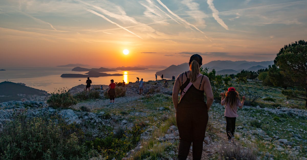 A group of people hiking on a coastal trail at sunset, enjoying breathtaking sea views.