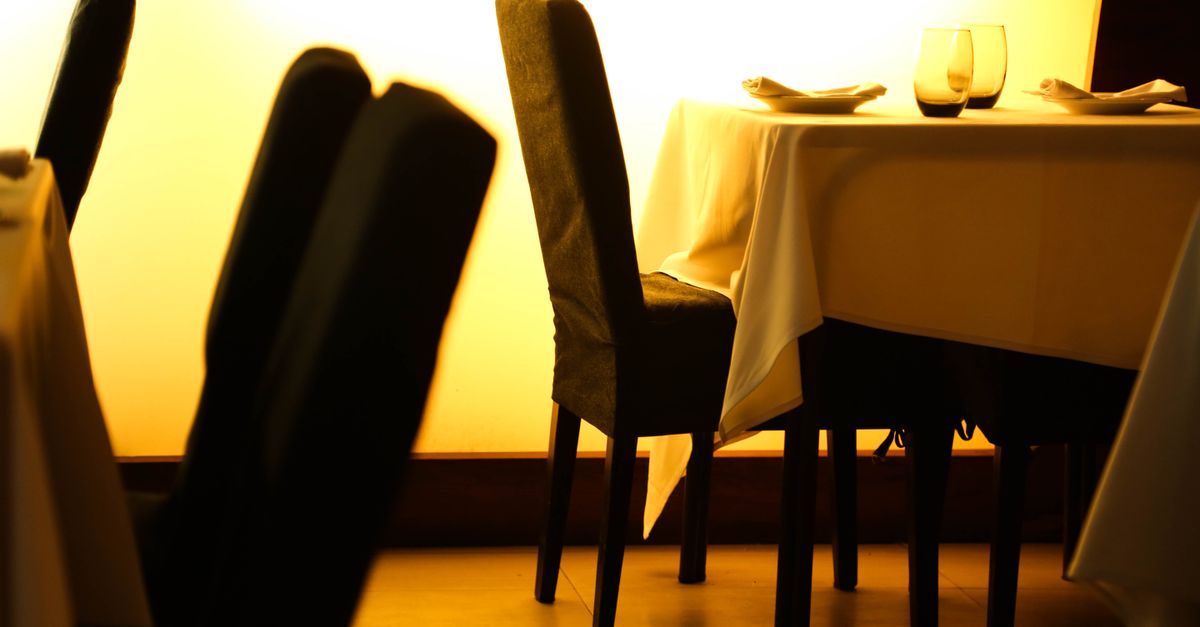 Cozy restaurant setting with elegantly set table and warm ambient lighting.