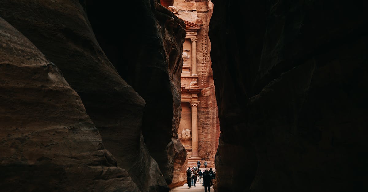 People walking through the Siq towards the stunning Al-Khazneh in Petra, Jordan.