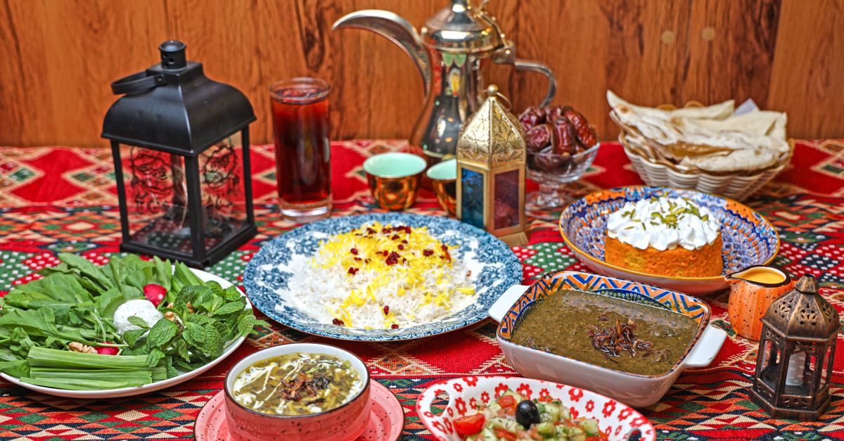 A traditional Middle Eastern feast with rice, stew, and appetizers on a decorative table setting.