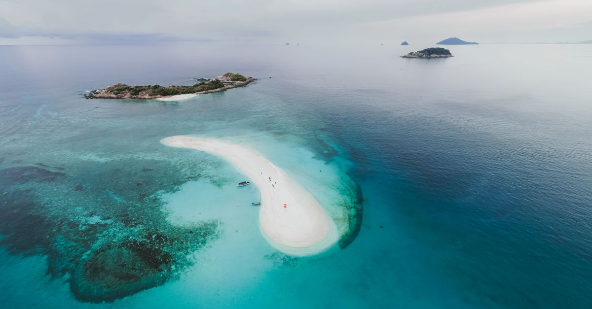 Stunning aerial photo of tropical islands and sandbar with clear blue water.