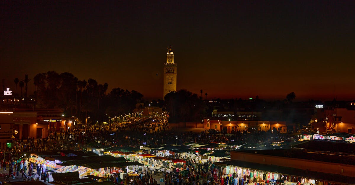 Experience the bustling night market in Marrakesh, Morocco, illuminated against a stunning twilight sky.