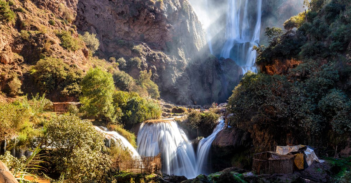 Stunning multi-tiered waterfalls cascading through mossy rocks in a lush forest setting under daylight.