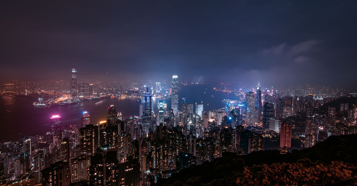Stunning night view of Hong Kong's illuminated skyscrapers and vibrant cityscape captured from an elevated perspective.