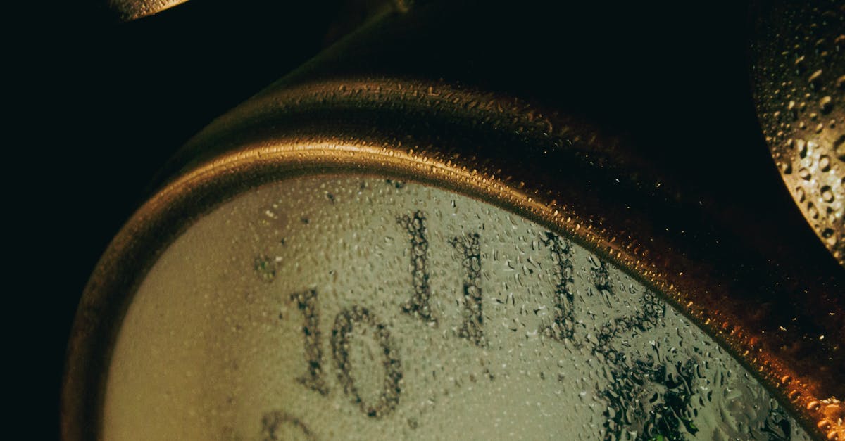 A detailed close-up of an alarm clock face covered with water droplets, creating a moody atmosphere.