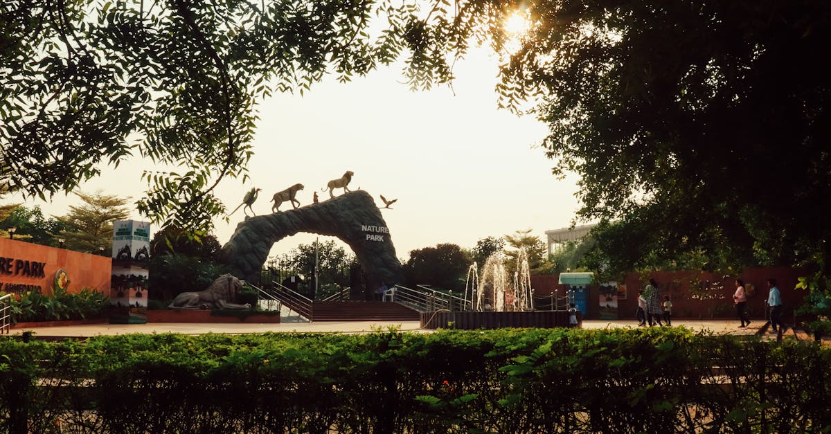 Visitors stroll by the Nature Park entrance under a scenic sunset, surrounded by lush greenery.