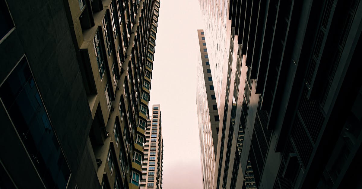A dramatic low angle view of skyscrapers reaching into the cloudy sky in Taguig City, Philippines.