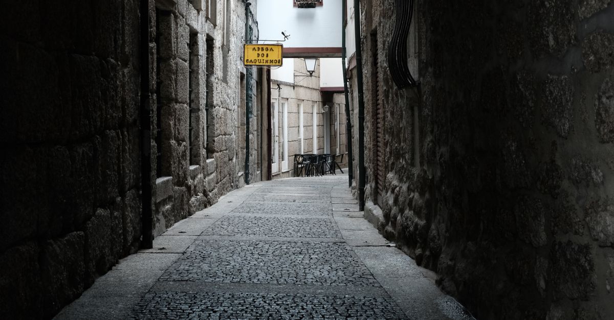 Captivating narrow alley with stone walls in Guimarães, Portugal, evoking a sense of history.