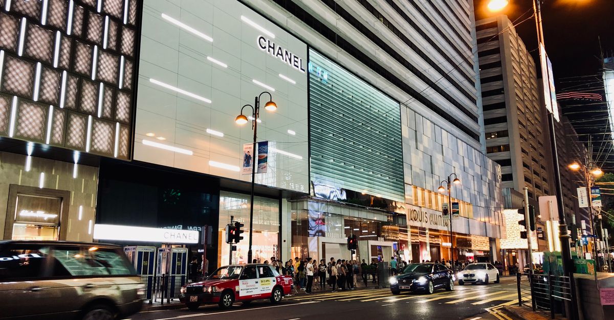 Vibrant nightlife scene capturing cars and people in Kowloon's shopping district, Hong Kong.