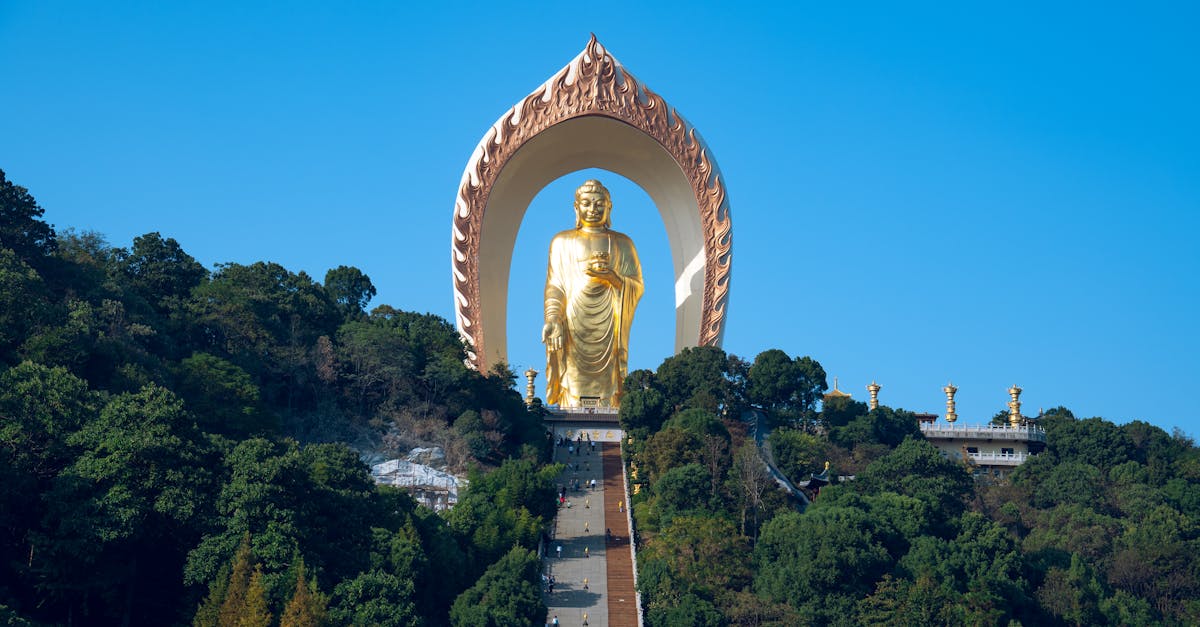 Majestic view of the Spring Temple Buddha statue surrounded by lush greenery and clear skies in Jiujiang, Jiangxi Province, China.