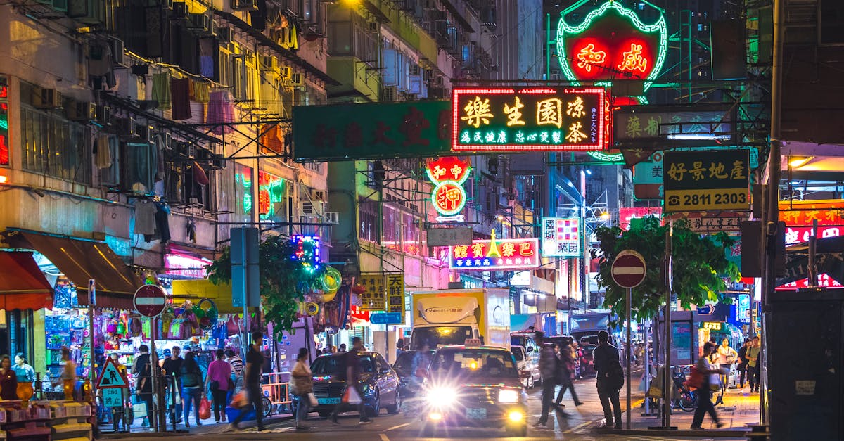 Colorful neon lights illuminate a bustling street in the New Territories, Hong Kong, by night.