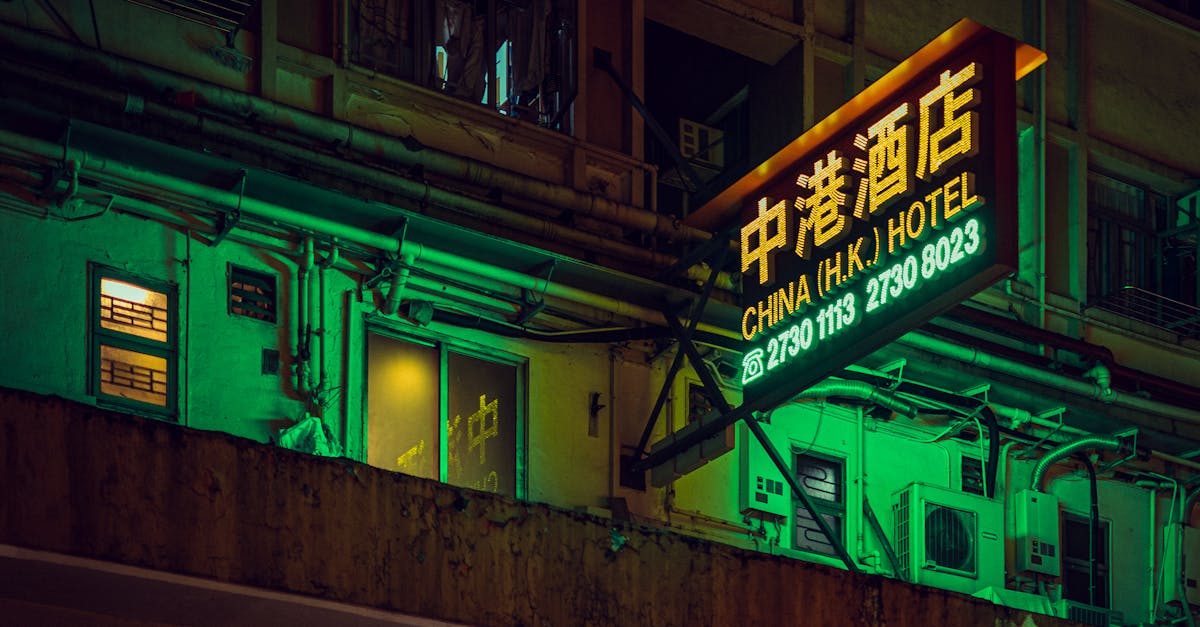 A neon-lit hotel sign illuminates the bustling streets of Hong Kong, capturing the city's vibrant nightlife.