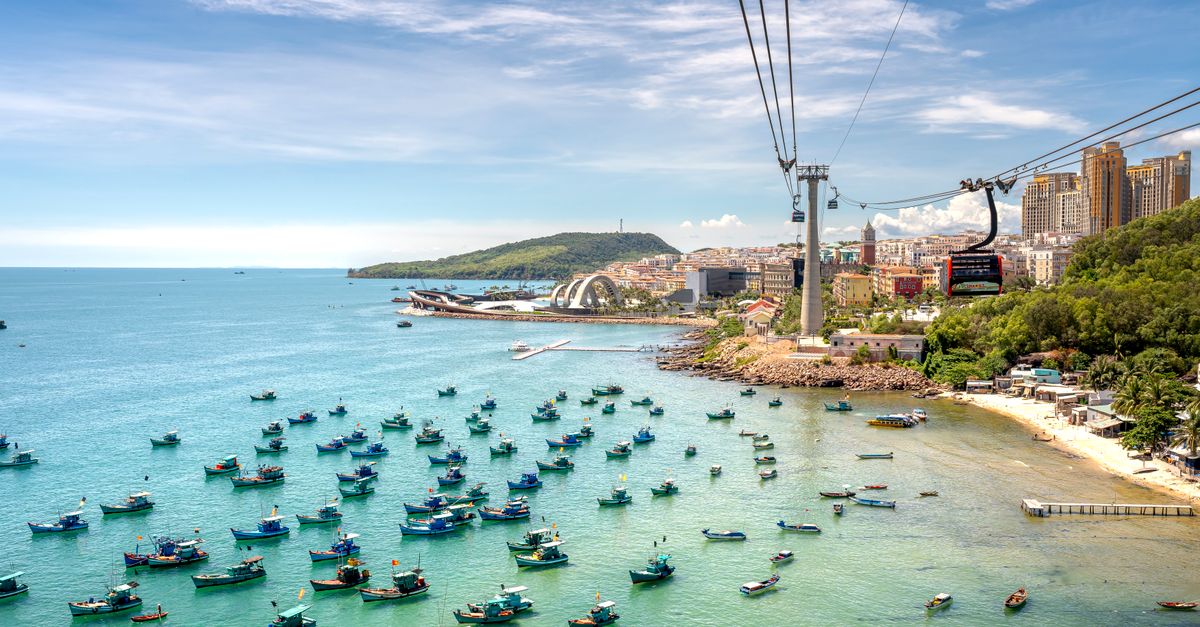 A breathtaking aerial view showcasing a vibrant coastline in Vietnam with cable cars and boats.