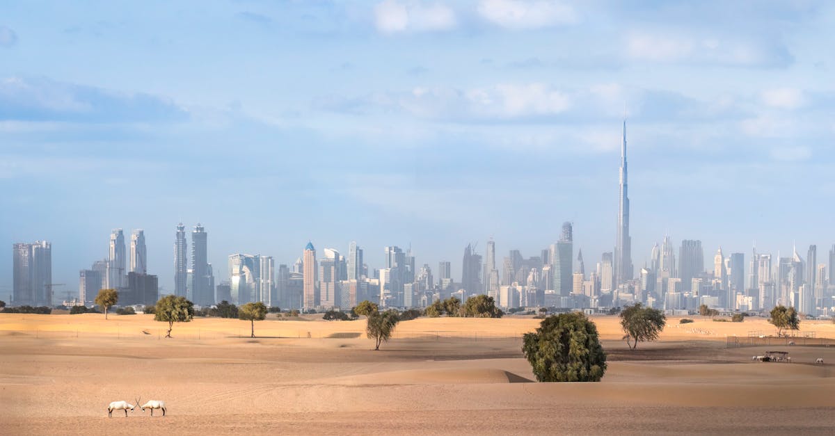 A stunning view of Dubai skyline featuring Burj Khalifa with desert foreground and clear skies.