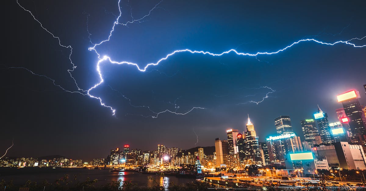 A striking image of a city skyline illuminated by a powerful lightning storm at night.