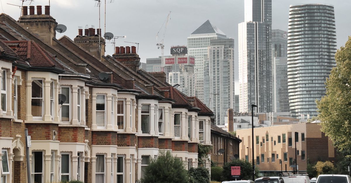 View of traditional London houses against the modern Canary Wharf skyline.