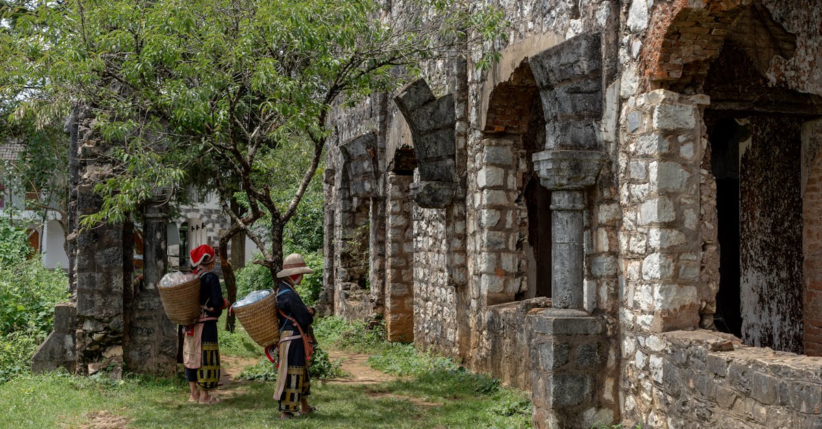 Two people in traditional attire near ancient stone ruins, symbolizing heritage.