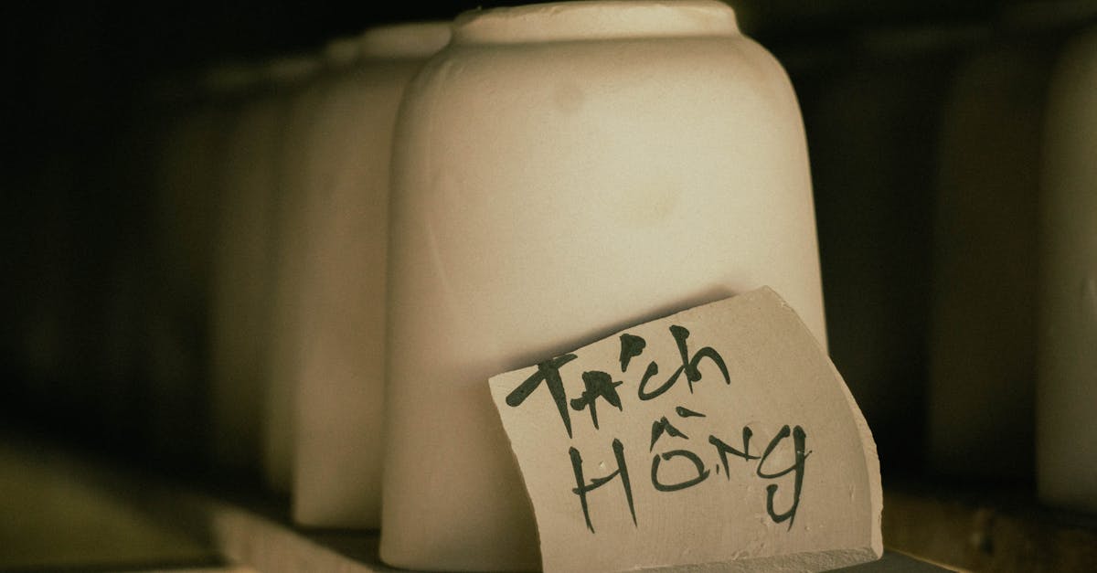Row of unglazed ceramic pots in workshop with handwritten label.