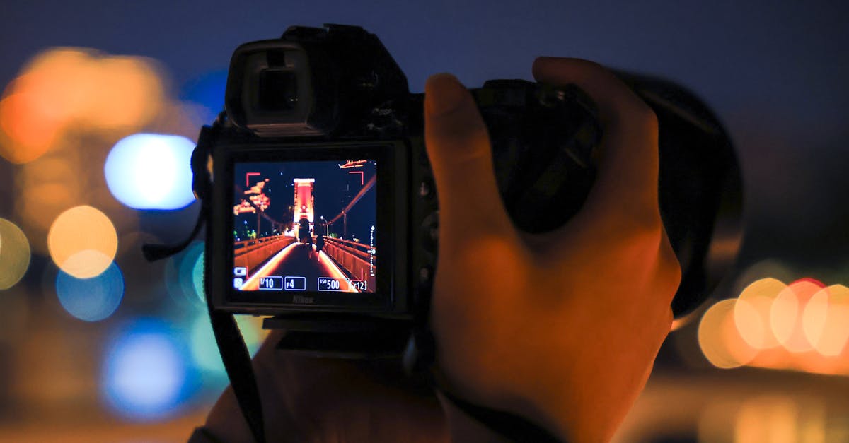 Close-up of a camera capturing a bridge at night, showcasing urban photography skills.