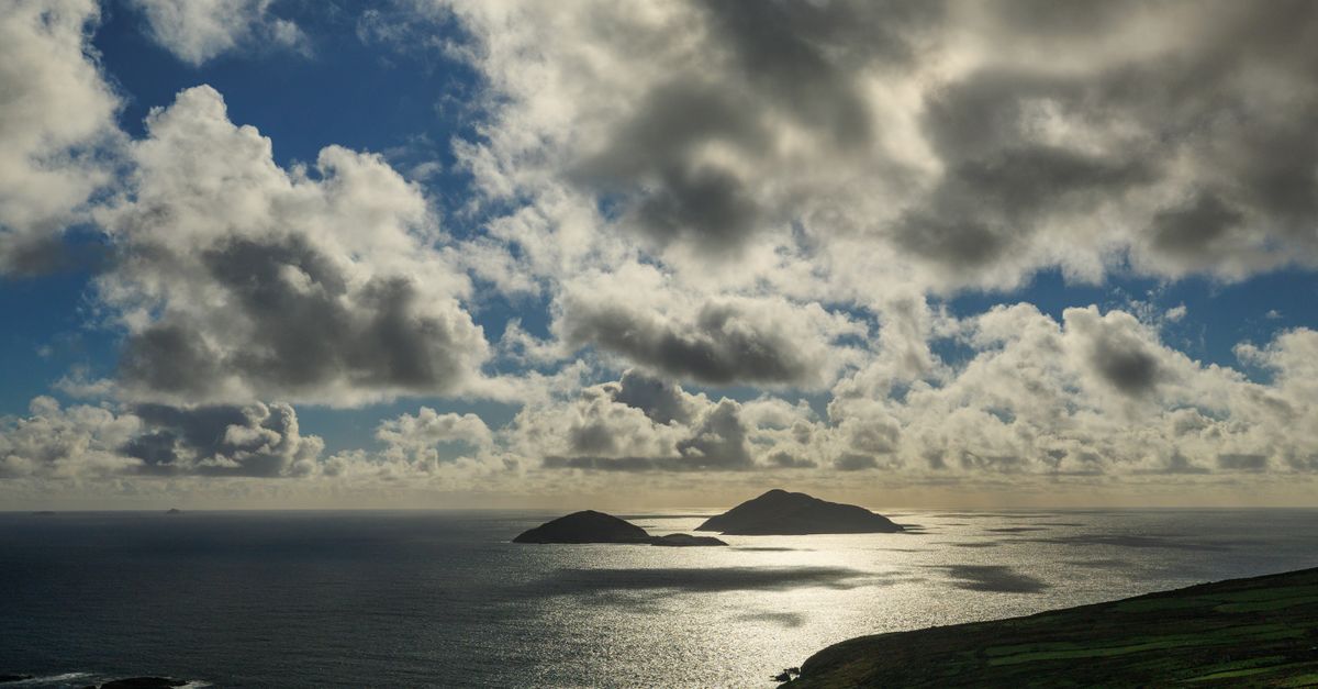 Dramatic clouds over Skellig Islands in Ireland with shimmering sea view.