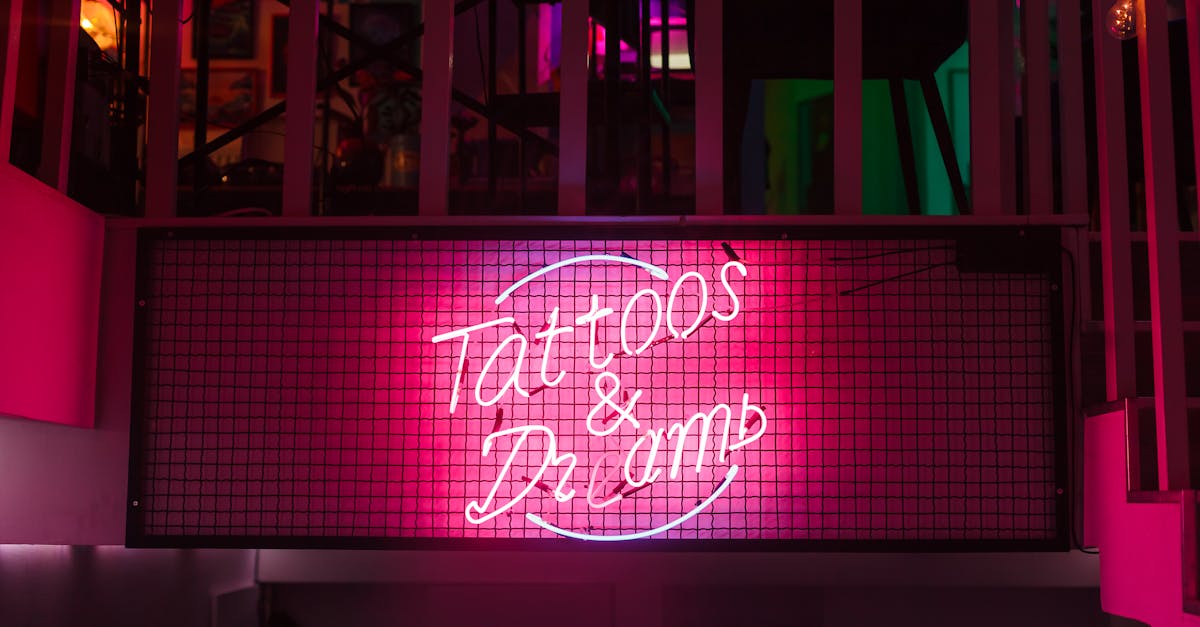 Vibrant neon sign "Tattoos &amp; Dreams" inside a cozy tattoo studio.