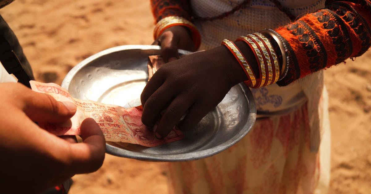 Two individuals exchanging Indian currency outdoors, highlighting cultural attire and transactional theme.