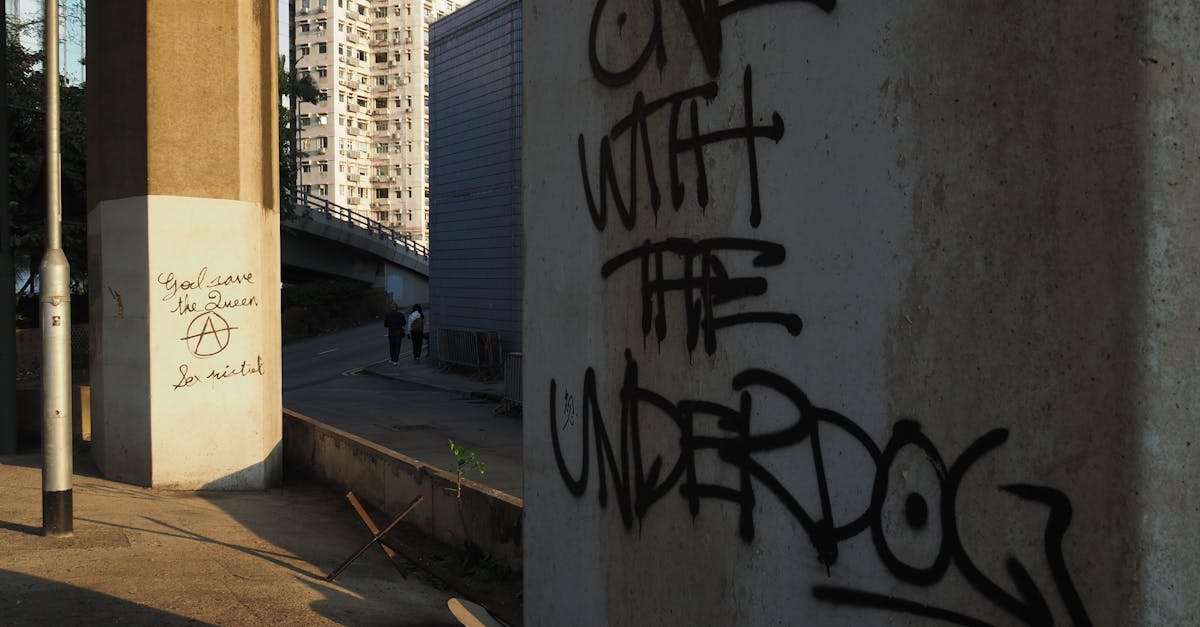 Graffiti art in an urban Hong Kong setting with high-rise buildings in the background.