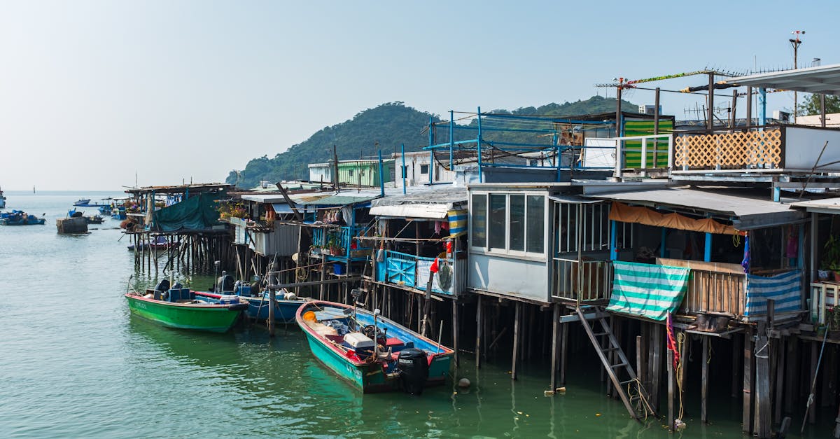 Scenic view of stilt houses along waterfront in New Territories, Hong Kong, with moored colorful boats.
