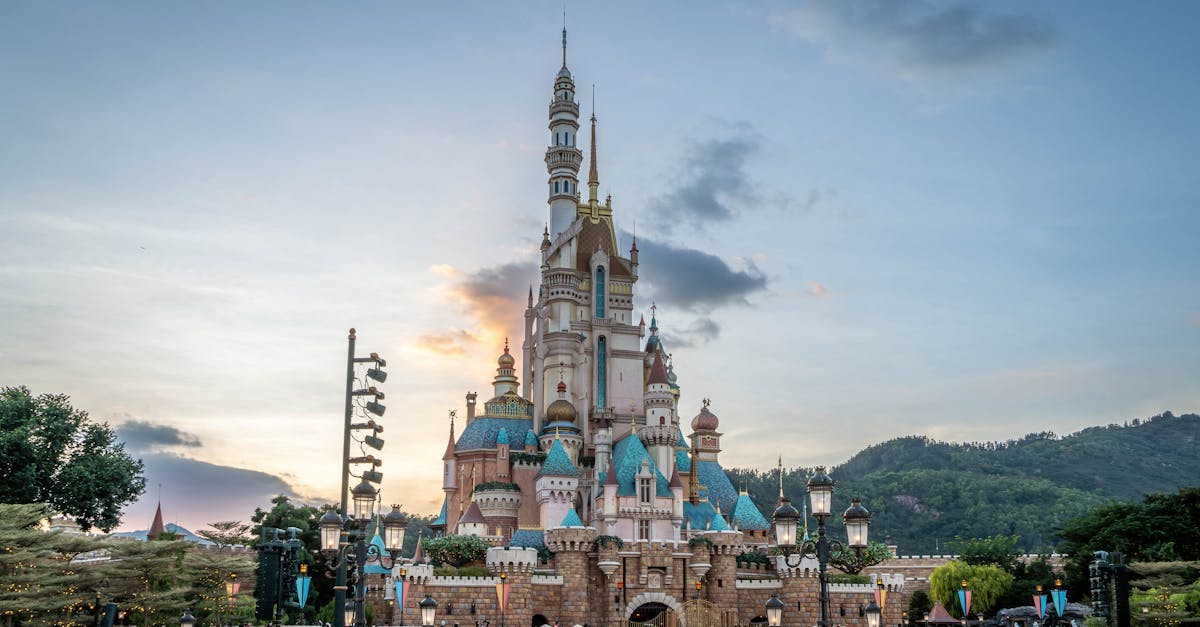 Magical fairytale castle at Hong Kong Disneyland with crowds at sunset.