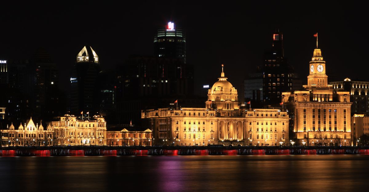 Dramatic night view of Shanghai Bund buildings beautifully illuminated along the Huangpu River.
