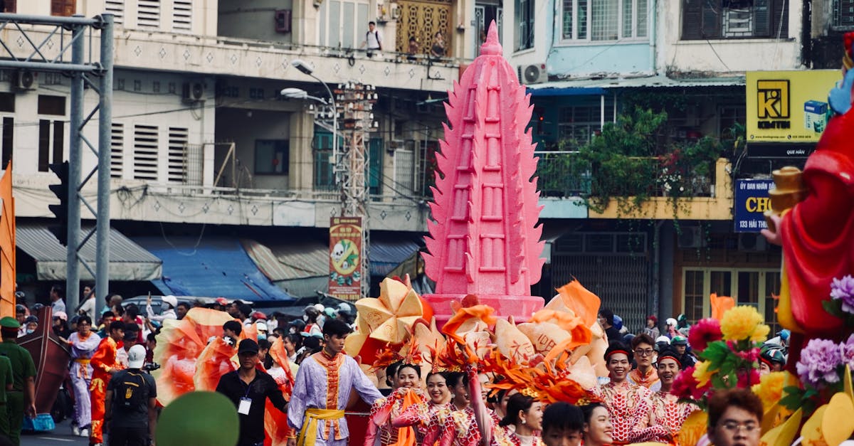 Vibrant street parade with participants in traditional attire at a busy city locale.