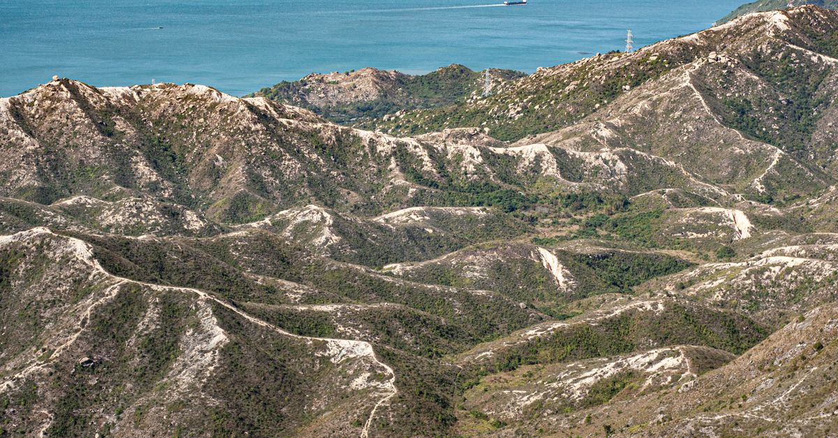 Scenic aerial view of Hong Kong’s rugged mountain terrain leading to the coastal waters.