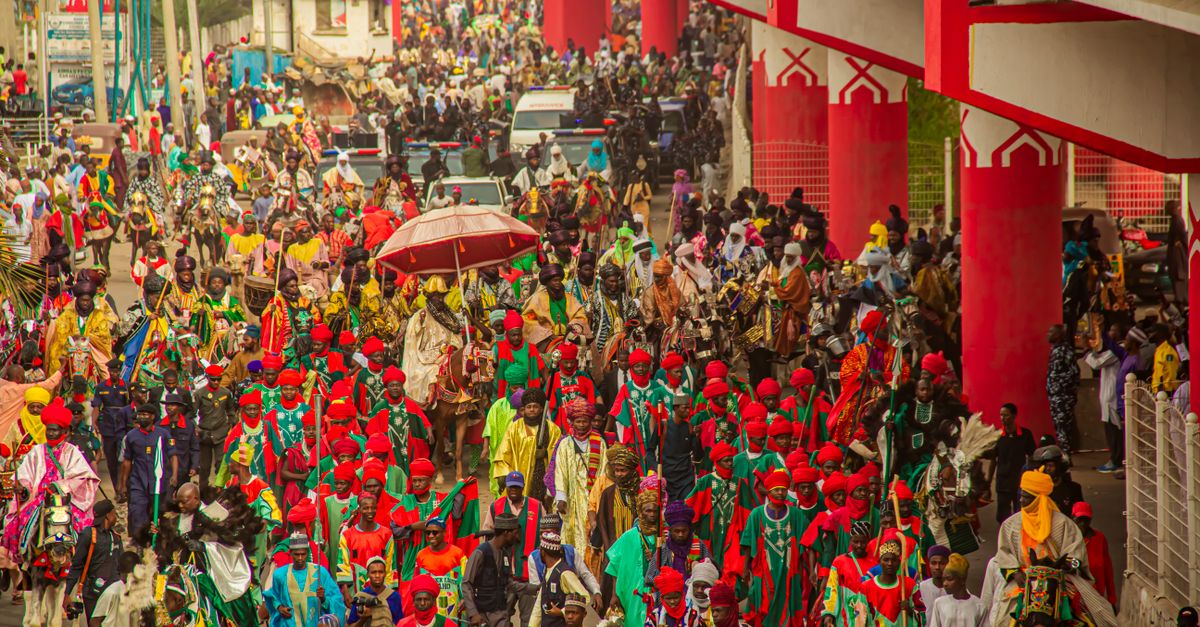 A colorful celebration of African culture with a parade in a bustling city setting.