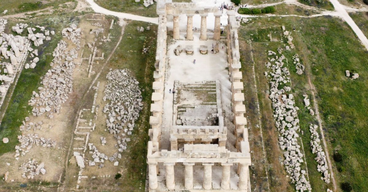 Aerial shot of ancient Greek temple ruins showcasing columns and stone pathways.
